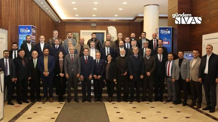 Bir salonun girişinde, STSO yazılı pankartların önünde çok sayıda kişi toplu halde duruyor.