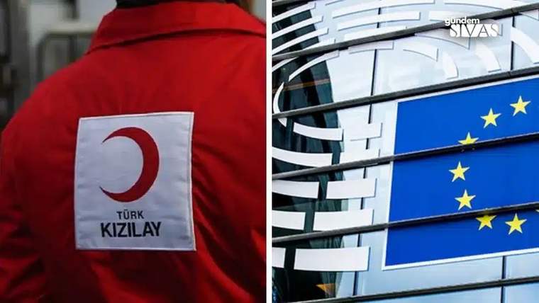 Kırmızı montta Türk Kızılay logosu, yanında cam cepheli binada Avrupa Birliği bayrakları görülüyor.