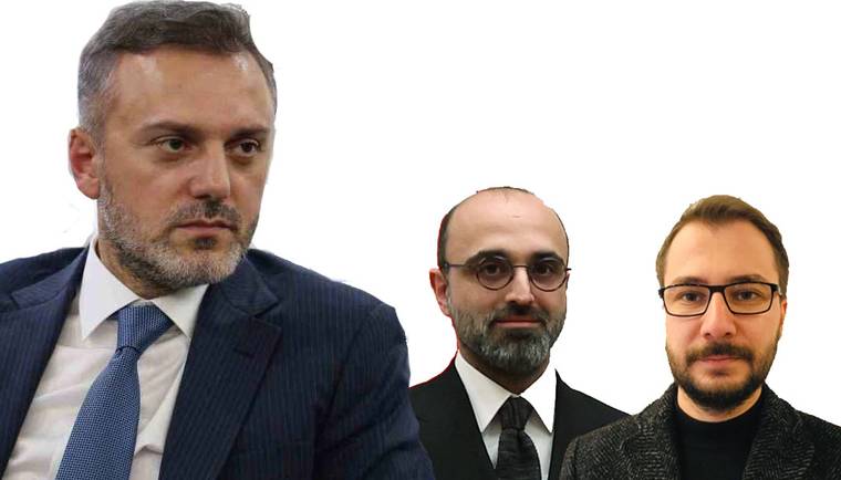Beyaz arka plan önünde takım elbiseli üç erkek; ortadaki ve sağdaki gözlük takıyor.