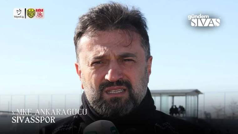 Sakallı bir kişi, açık havada mikrofonlara konuşuyor; görüntüde MKE Ankaragücü ve Sivasspor yazıları görülüyor.