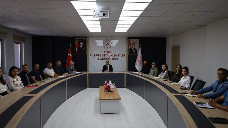 Sivas Aile ve Sosyal Hizmetler İl Müdürlüğü yazılı panonun önünde, toplantı masasında oturan kişiler