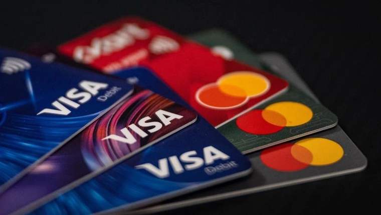Üzerinde Visa ve Mastercard logoları bulunan kredi kartları, üst üste yerleştirilmiş.