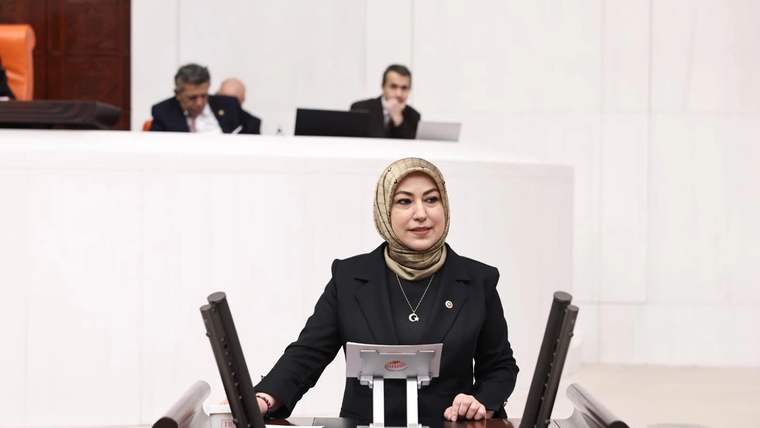 Kürsüde konuşan bir kadın milletvekili, arka planda diğer milletvekilleri görünüyor.