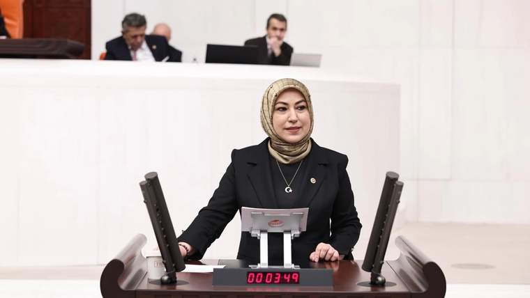 Kürsüde konuşan bir kadın milletvekili, arka planda diğer milletvekilleri görünüyor.