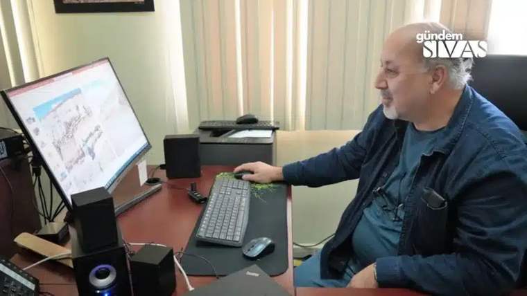 Bilgisayar ekranına bakan bir kişi, ofis ortamında oturuyor.