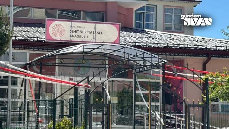 Girişinde “Şehit Nuri Yazanel Anaokulu” tabelası bulunan, kırmızı ve beyaz cepheli okul binası.