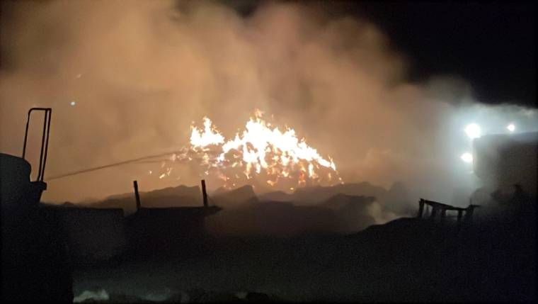Gece karanlığında büyük bir yığın alevler içinde yanarken çevresini yoğun duman kaplıyor.