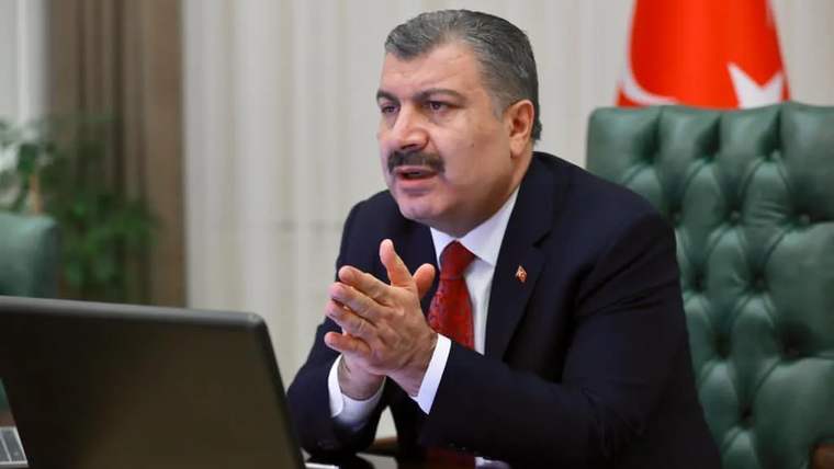 Kahverengi bir koltukta oturan bir kişi, bilgisayar ekranına bakarak elini açmış.