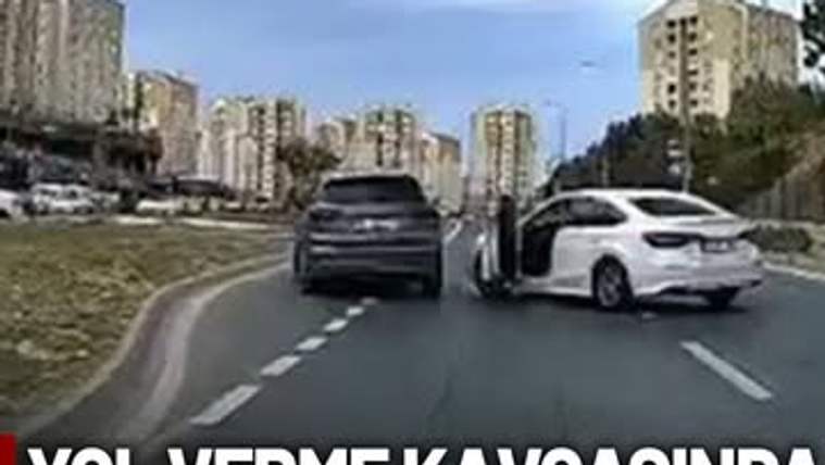 İki araç, yol verme kavgası sırasında yan yana ilerliyor; bir araçta kapı açık.
