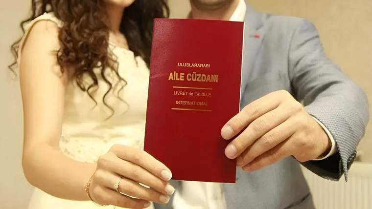 Bir çift, uluslararası aile cüzdanını elinde tutuyor.