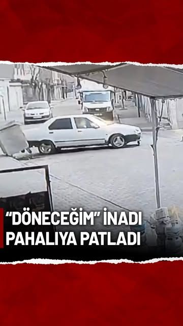 Beyaz bir otomobil, çöp konteynerine çarparak kaldırımda duruyor.