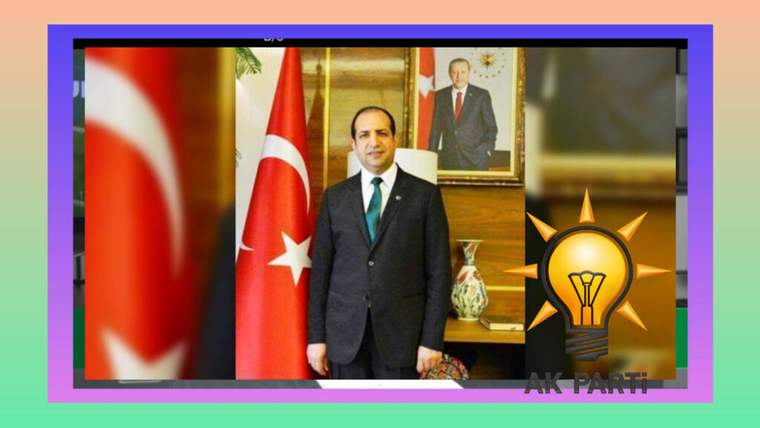 Takım elbiseli bir erkek, Türk bayrakları ve duvarda asılı portre önünde duruyor; yanında AK Parti logosu bulunuyor.