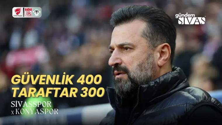Bir kişi, yanındaki yazılı pankartla birlikte stadyumda duruyor.