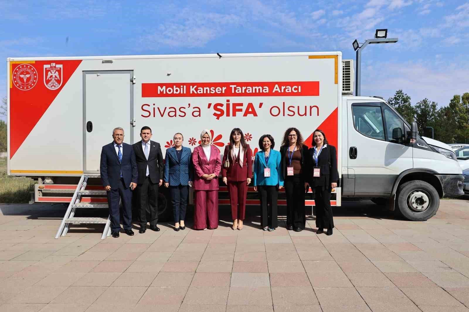Üzerinde “Mobil Kanser Tarama Aracı” yazan aracın önünde yedi kişi yan yana duruyor.