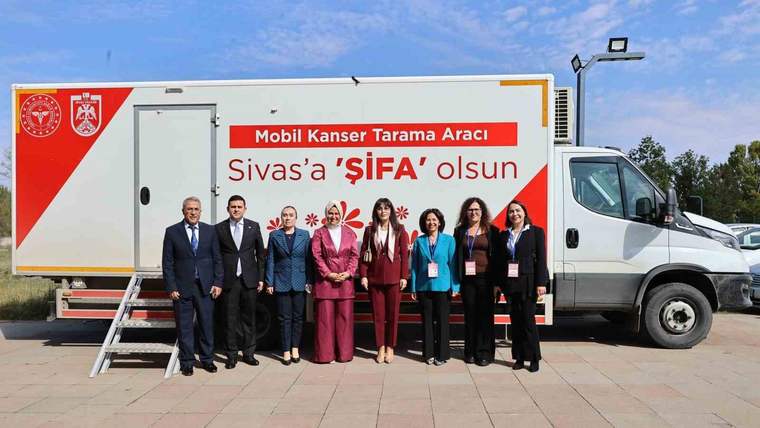 Üzerinde “Mobil Kanser Tarama Aracı” yazan aracın önünde yedi kişi yan yana duruyor.