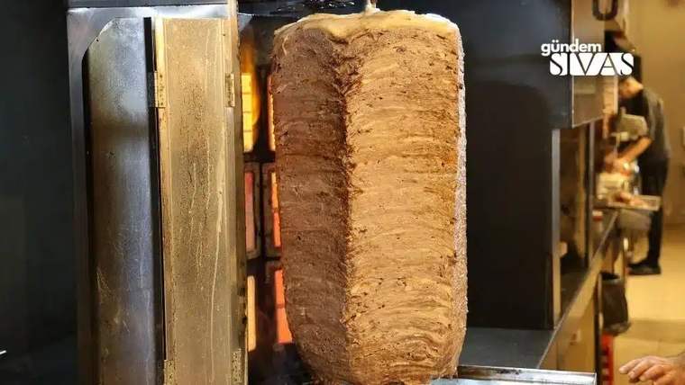 Döner kebap pişirilen döner şişi, dönerin üst kısmında yağ birikintileriyle birlikte görünmekte.