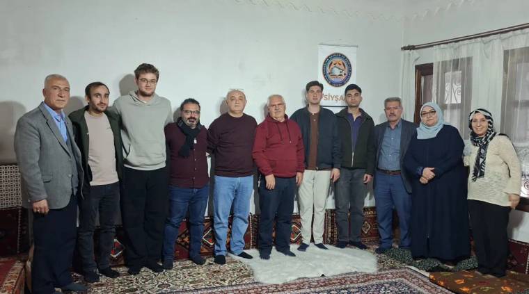 SİYŞAD atölyesinde bir grup insan, yan yana durarak fotoğraf çektiriyor.