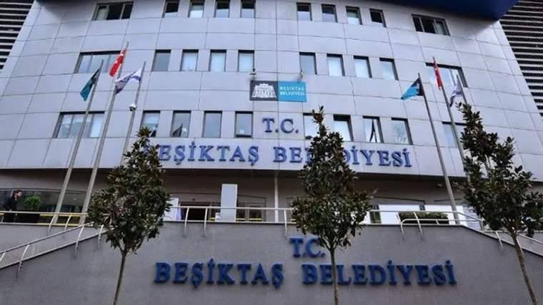 Üzerinde “T.C. Beşiktaş Belediyesi” yazan belediye binasının ön cephesinde bayraklar ve ağaçlar görülüyor.