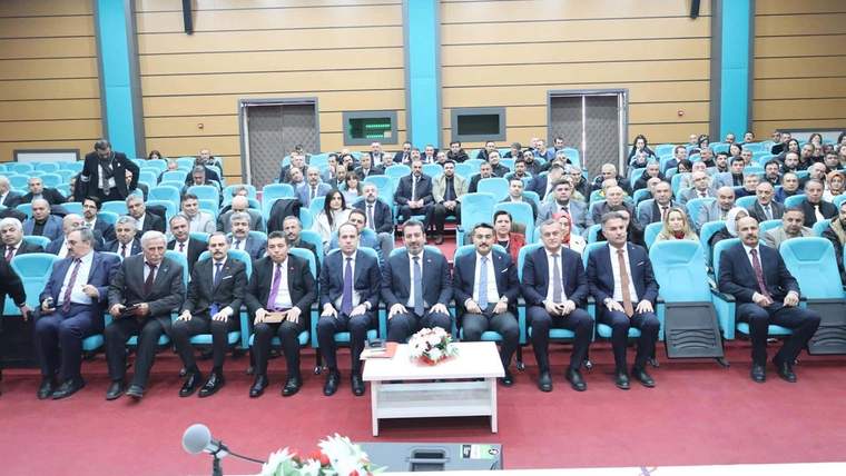 Eğitim yöneticilerinin katıldığı bir toplantı salonunda oturan kalabalık bir grup.