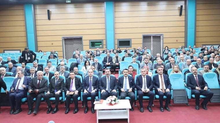 Eğitim yöneticilerinin katıldığı bir toplantı salonunda oturan kalabalık bir grup.