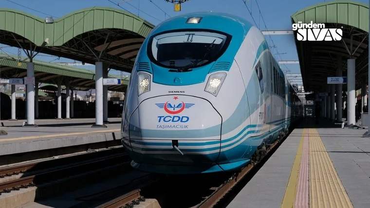 İstasyonda duran, önünde TCDD Taşımacılık yazısı bulunan beyaz ve mavi hızlı trenin önü görülüyor.