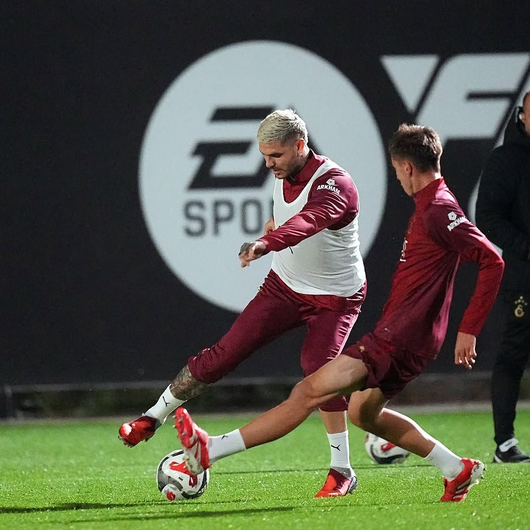 Antrenman sahasında futbolcular, top ile çalışma yapıyor.