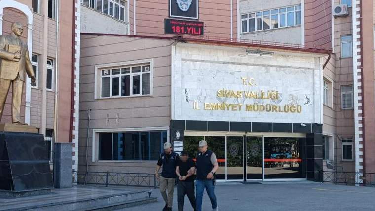 İki kişi, Sivas Emniyet Müdürlüğü önünde polisler tarafından gözaltına alınıyor.
