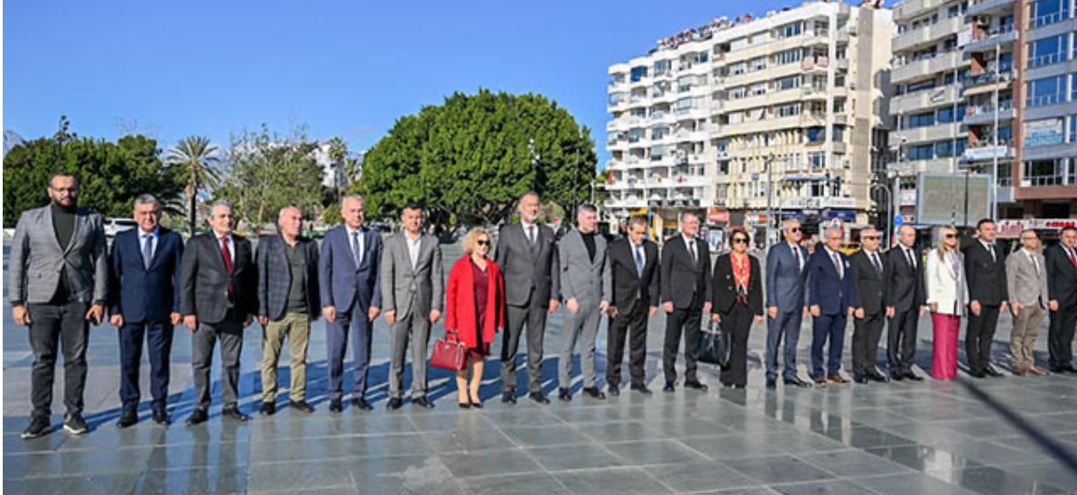 Açık havada bir arada duran, çoğu takım elbiseli kadın ve erkeklerden oluşan kalabalık grup