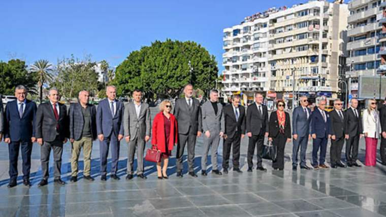 Açık havada bir arada duran, çoğu takım elbiseli kadın ve erkeklerden oluşan kalabalık grup
