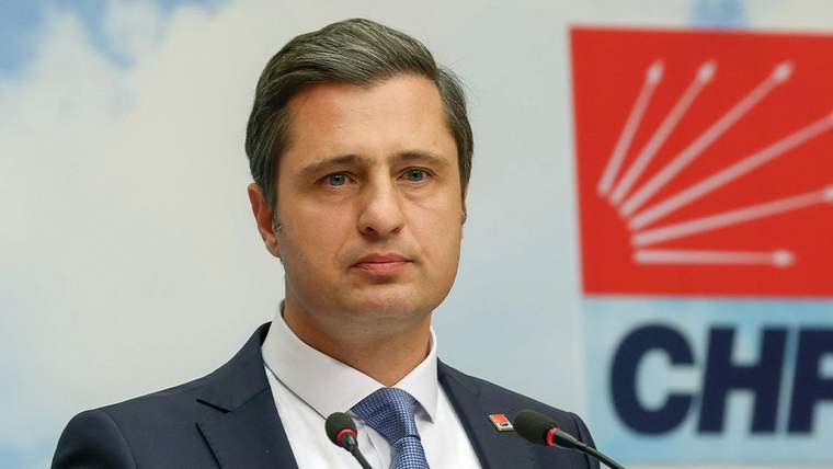 CHP logosunun arkasında, mikrofonların önünde bir kişi konuşuyor.