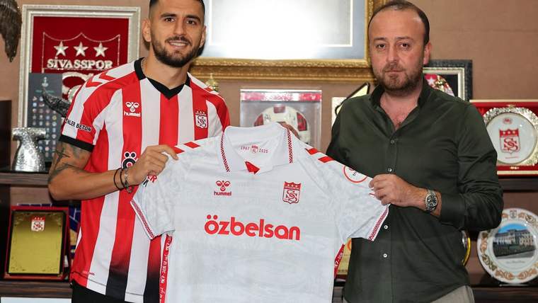 İki erkek, üzerinde Sivasspor arması ve Özbelsan yazısı bulunan formayı birlikte tutuyor.