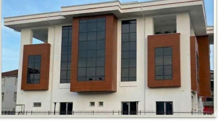 Yeni inşa edilen sağlık kompleksi binası, geniş cam cepheleri ve kahverengi panelleriyle dikkat çekiyor.