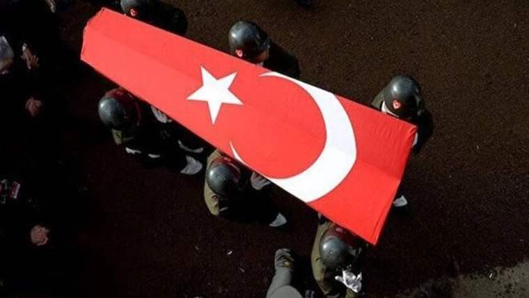 Türk bayrağına sarılı bir tabut, askerler tarafından taşınıyor.