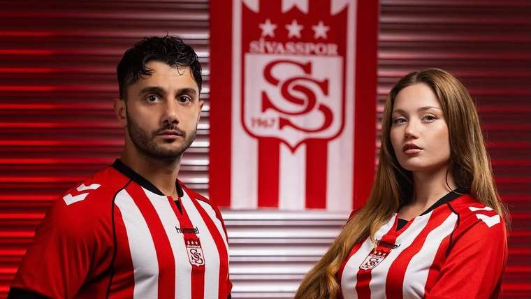 Kırmızı-beyaz çizgili formalar giyen bir erkek ve bir kadın, Sivasspor arması önünde duruyor.