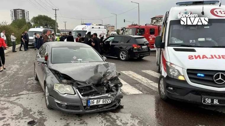 Kaza sonrası hasar görmüş bir otomobil, çevresinde toplanmış insanlar ve acil yardım araçları var.