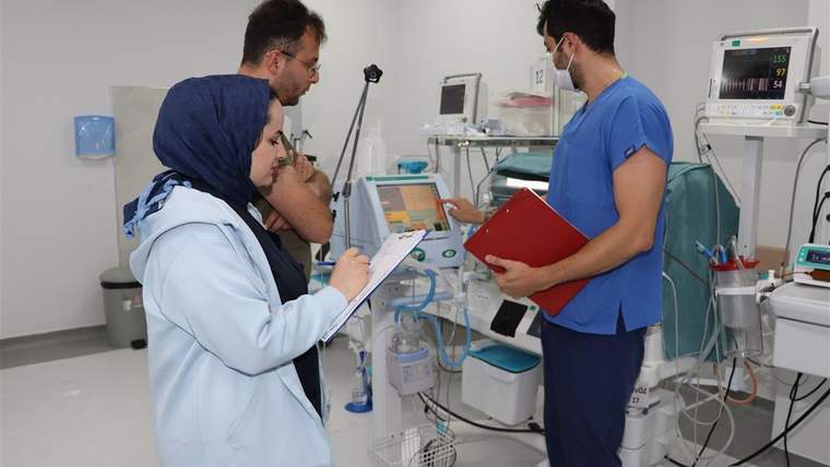 Üçüz doğumunu gerçekleştiren sağlık çalışanları, hastane odasında bilgi alıyor.