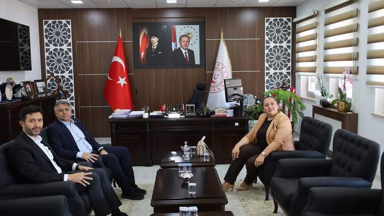 Sivas Aile ve Sosyal Hizmetler İl Müdürlüğü'nde üç kişi oturuyor, arka planda Türk bayrağı ve Atatürk portresi var.