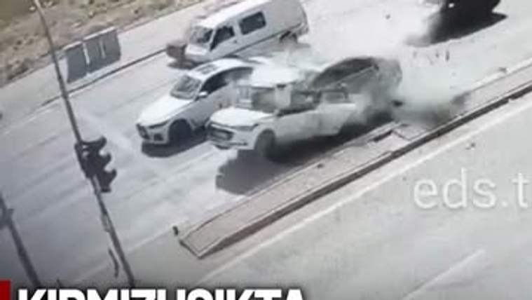 Kavşakta çarpışmış araçlar, savrulan parçalar ve trafik ışıkları güvenlik kamerası görüntüsünde görülüyor.