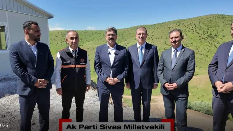 Bir grup erkek, yeşil bir alanda duruyor; ön planda Ak Parti Sivas Milletvekili yazılı bir pankart var.