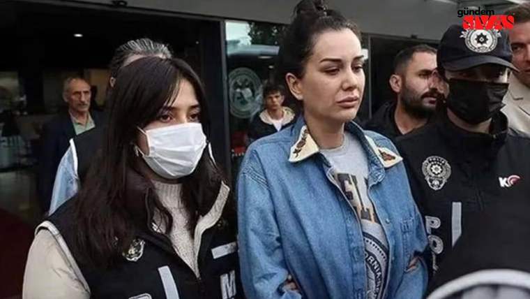 Maske takan bir kadın, yanında başka bir kadınla birlikte polisler tarafından çevrelenmiş.