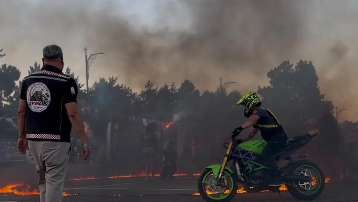 Alevlerin etrafında dönen bir motosikletli, festival alanında gösteri yapıyor.