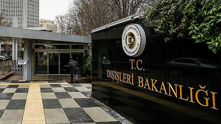 Dışişleri Bakanlığı yazılı siyah taş tabela, bina girişinin yanında ve kare taş döşeli alanda görülüyor.
