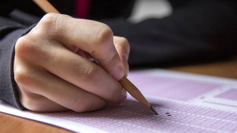 Kurşun kalem tutan bir el, mor tonlu optik cevap formundaki baloncuklardan birini işaretliyor.
