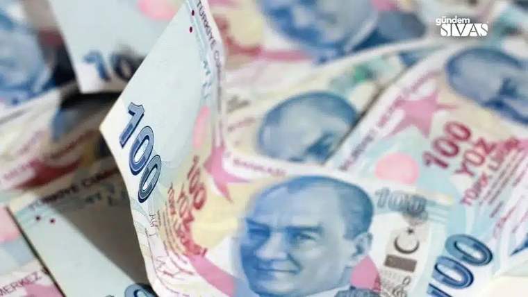 Üst üste duran Türk lirası banknotları arasında ön planda 100 liralık bir banknot görülüyor.