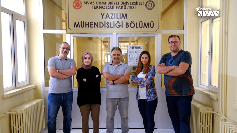 Sivas Cumhuriyet Üniversitesi Teknoloji Fakültesi Yazılım Mühendisliği Bölümü önünde beş kişi duruyor.