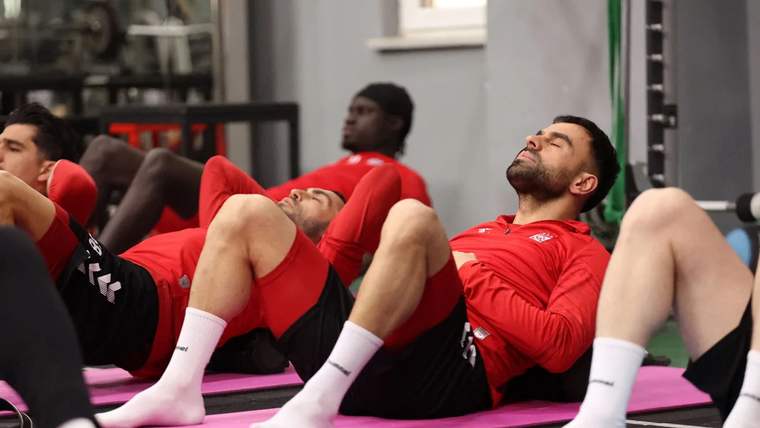 Sivasspor futbolcuları, antrenman sırasında dinlenme pozisyonunda yerde yatıyor.