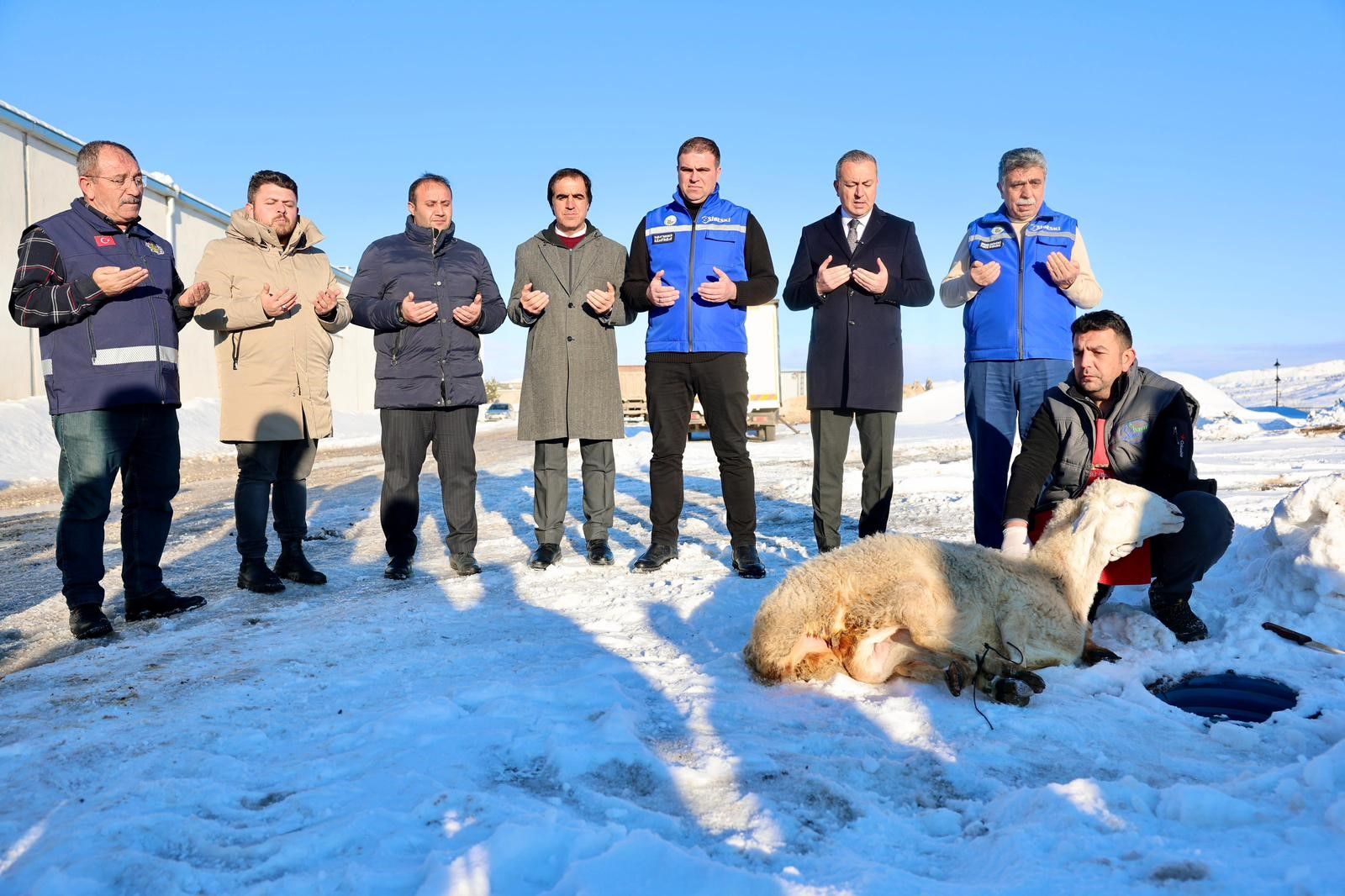 Kar yağışı sonrası bir grup insan, karla kaplı alanda dua ederken, önlerinde bir koyun yatıyor.