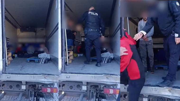 Bir polis memuru, kamyonun arkasında düzensiz göçmenleri kontrol ediyor.