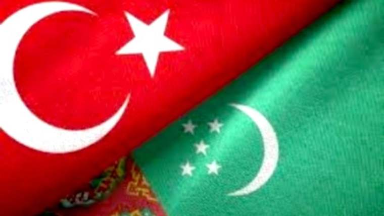 Türk bayrağı ile yeşil zeminli, üzerinde yıldız ve hilal bulunan başka bir bayrak yan yana duruyor.