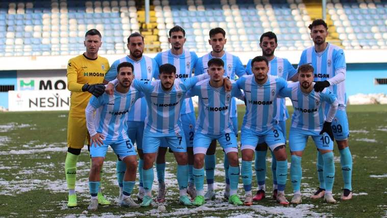 Pazarspor futbol takımı, karla kaplı sahada poz veriyor.